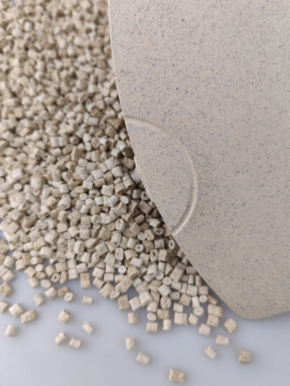 Close view of a bamboo fiber ABS molded sample plaque and pellets