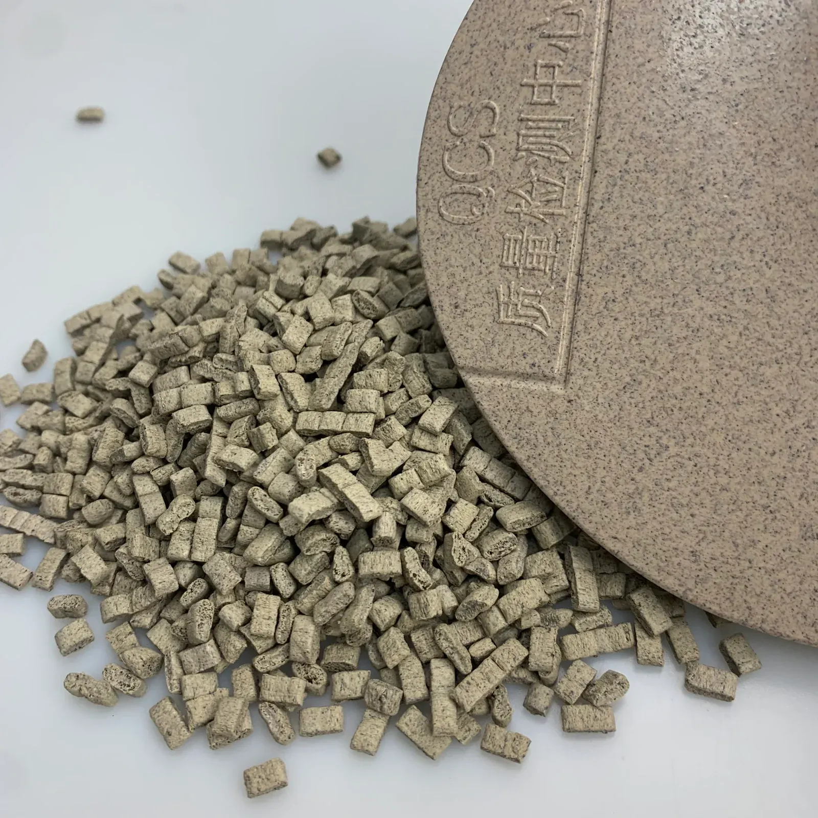 Close view of tea fiber PP masterbatch pellets and a molded plaque
