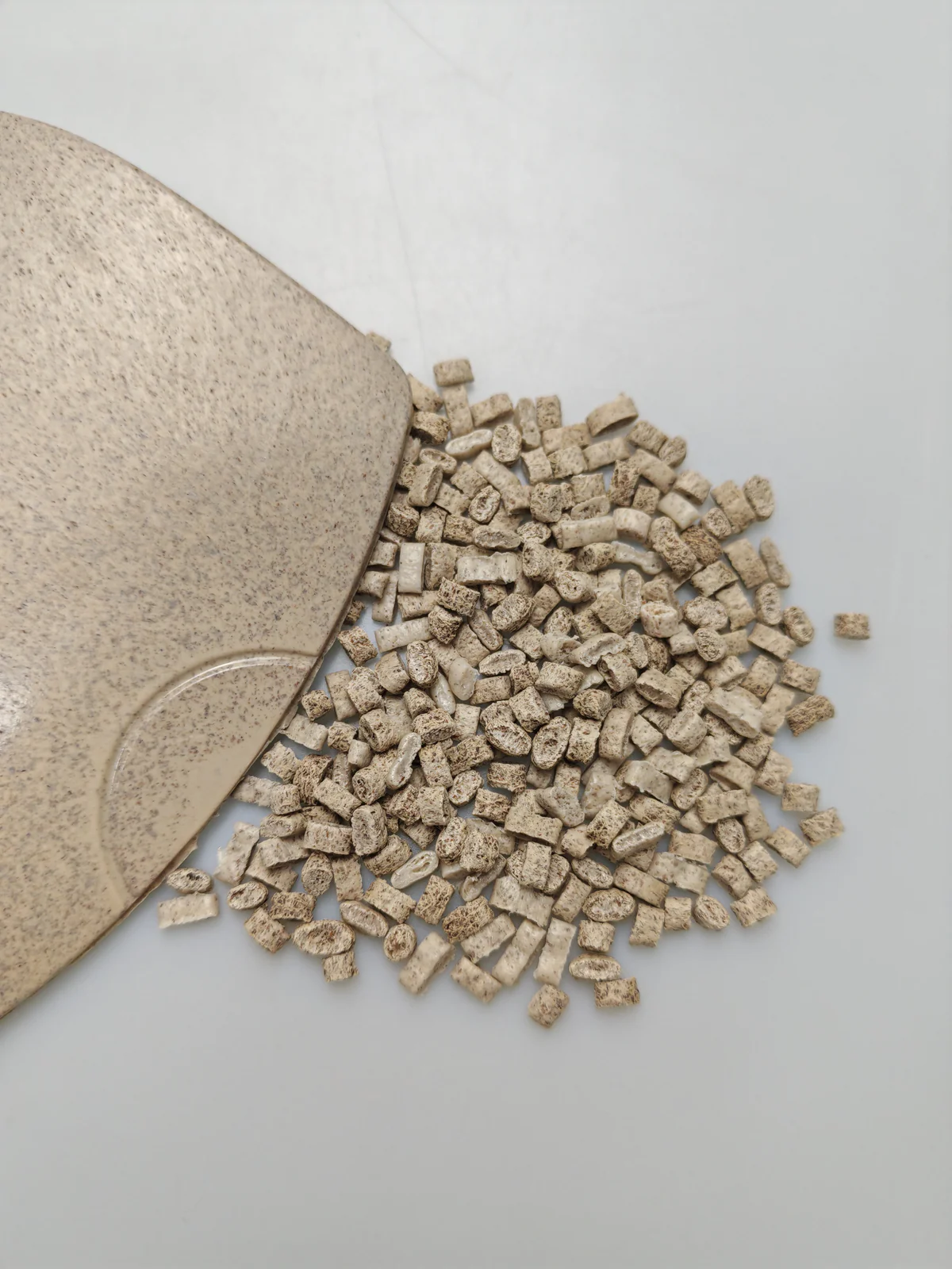 Wheat straw fiber PE sample plaque beside pellets