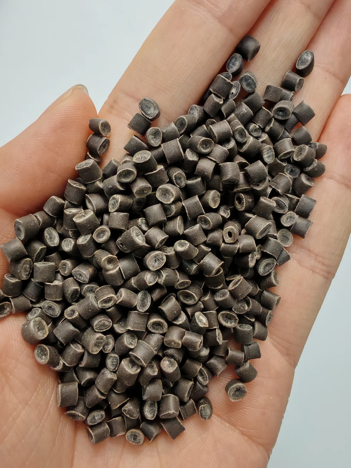 Coffee ground fiber PP pellets held in hand